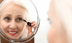 mature woman applying mascara