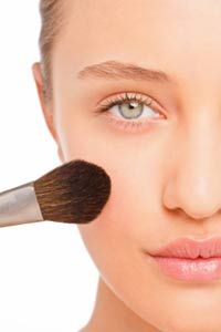 Clear faced woman with makeup brush.