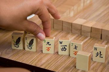Close-up of mahjong player moving tiles