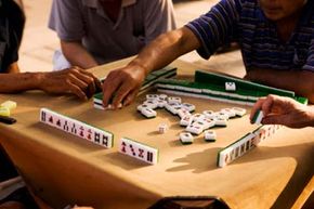Four men playing mahjong at table