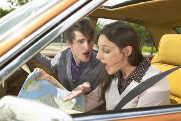 Young couple in car with map 