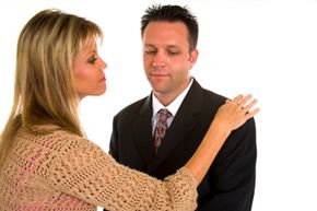 woman picking lint off man's jacket