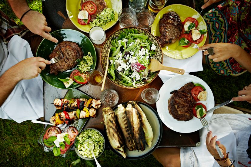 Overhead view of friends dining at table with food in backyard garden