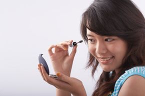Woman applying mascara. 