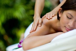 A woman getting a massage at a tropical spa