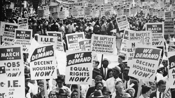 Crowd protesting social issues together, signs in hand.