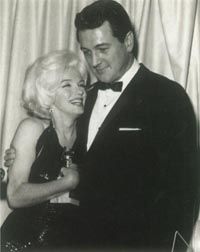 Marilyn hugs the Golden Globe award she received in early 1962; with her is Rock Hudson.