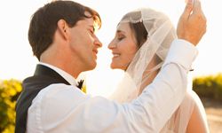 man lifting veil to kiss bride