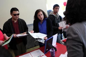 Skyline College students talk to a recruiter during a job fair in San Bruno, Calif. How can you stand out to MBA programs?