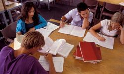 A group of four students studying together in a library.