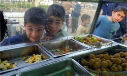Palestinian kids waiting for their falafel sandwich in East Jerusalem, Israel. The balls of falafel are on the right.