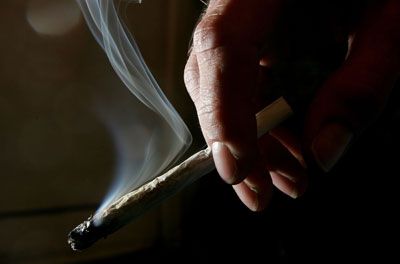 A customer at a cannabis dispensary in San Francisco holds a marijuana cigarette.