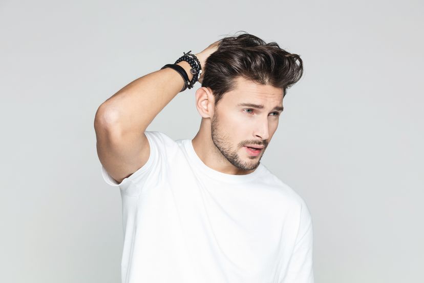 Portrait of handsome male model posing with hand in hair