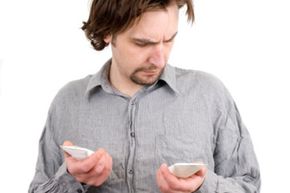 man reading tubes of moisturizer