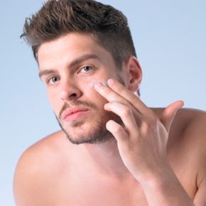 Man putting moisturizer on his face. 