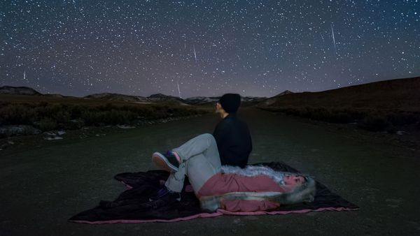 Men admiring the night sky's milky way and stars in the vastness of nature.