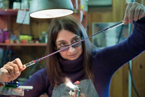 Glass artist Elena Rosso twists a zanfirico glass cane in Venice, Italy. Twisting different colors of molten glass together allows artists to create the patterns they desire.