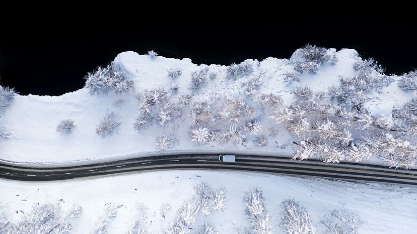 Car driving on snowy road at Lake Sils, aerial view, Switzerland
