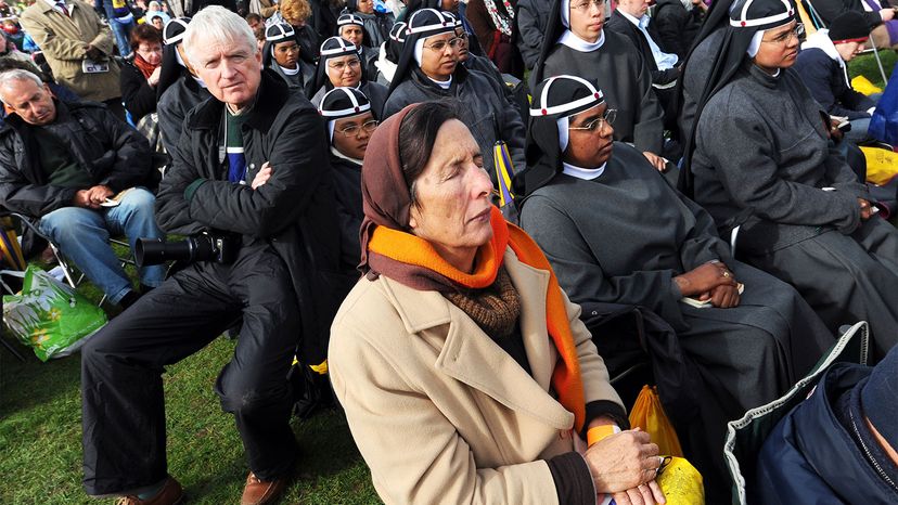 A woman closes her eyes in prayer as Pope Benedict XVI arrives to conduct a mas