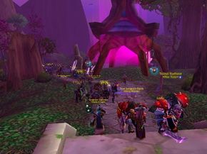 A large group of World of Warcraft characters in player-versus-player mode attacks the night elf capital city of Darnassus.