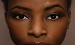 Close-up shot of dark-skinned woman with flawless complexion.