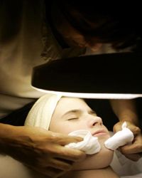 woman getting acne treatment from dermatologist