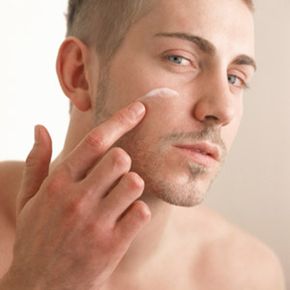 Man putting moisturizer on his face. 