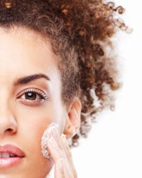 young woman applying moisturizer