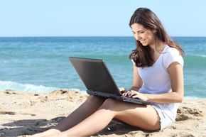 girl on laptop at beach