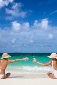 women in bathing suits on the beach with cocktails