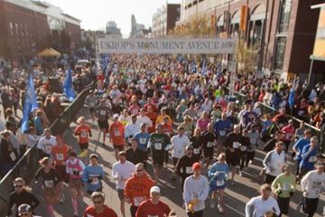 A large crowd celebrates at an outdoor event parade.