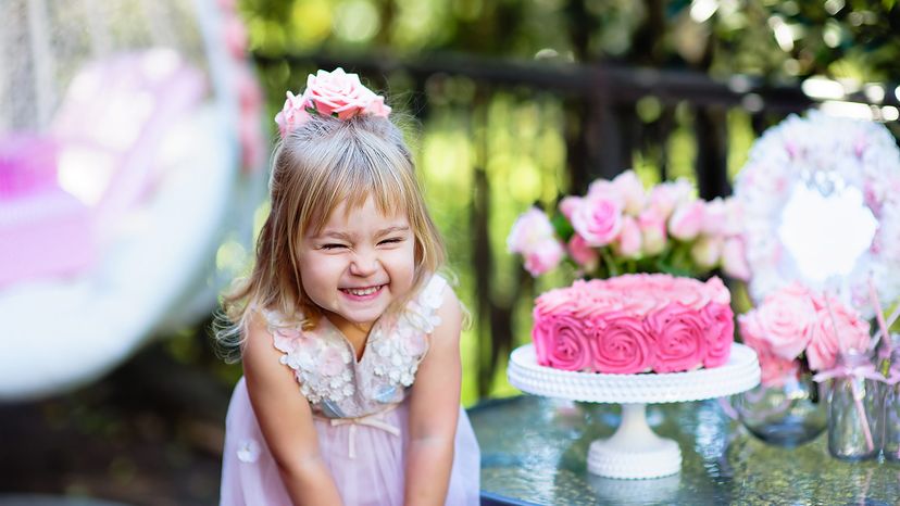 Little girl celebrates Birthday Party with rose decor in beautiful garden