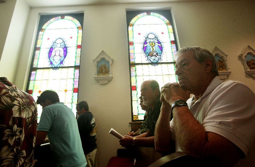 Worshipers pray inside St. Clare Catholic Church, in Waveland, Miss., which was completely destroyed by Hurricane Katrina and then rebuilt.