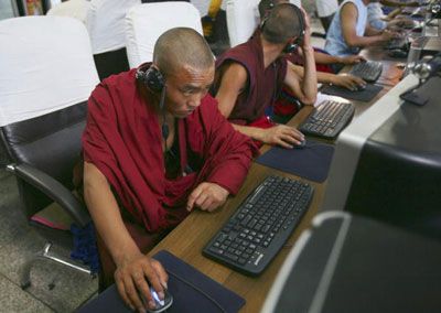 Adults using technology indoors on computers.