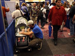 A father tends to his daughter while his wife looks for work at a job fair in Colorado in September 2008, after unemployment hit a seven-year high. See more recession pictures.