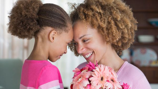 mother getting flowers from her little girl