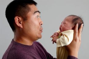asian dad holding infant