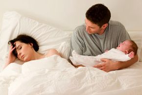 couple with baby in bed