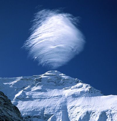 A lenticular cloud forms above the summit of Mount Everest, Tibet.