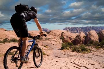 Person cycling outdoors on a bicycle mountain biking.