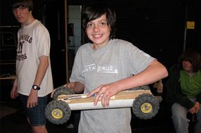 A student at Northfield School of Arts and Technology holds his mousetrap-powered car.