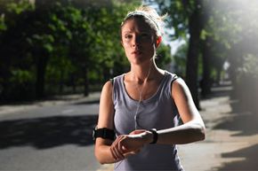 Runner wearing headphones and checking wrist watch
