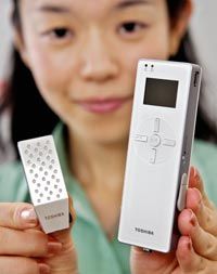 Toshiba employee Hiroko Mochida displays an MP3 player along with a prototype model of a direct methanol fuel cell (DMFC).