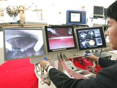 Man demonstrates Hitachi's prototype robot, MR Image-guided surgical robotic system for caparoscopic surgery.