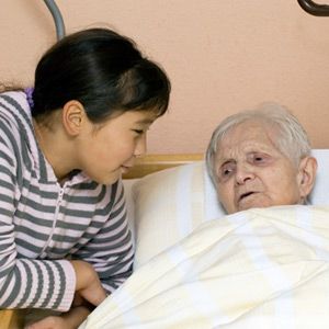 child visiting grandparent in nursing home