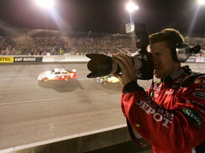 Carl Edwards, driver of the #99 Office Depot Ford, shoots a camera during the NASCAR Nextel Cup Series Chevy Rock & Roll 400 