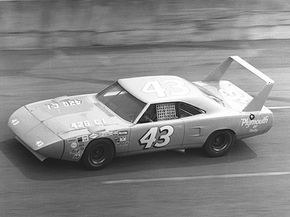 理查德·佩蒂（Richard Petty）在1970年的代托纳（Daytona）500中驾驶着这只普利茅斯（Plymouth）的超级鸟。超级鸟的巨大后翼和尖头的前端给它带来了可观的空气动力学优势。“width=