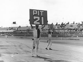 Prior to in-car radio communications between drivers and crews, chalkboards were used to inform drivers of their position on the track, margins between cars and when to come in for a pit stop.