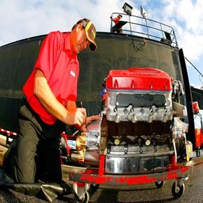 A crew member prepares an engine for a NASCAR race.