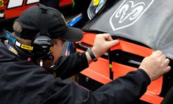 A crew chief applies duct tape to a car